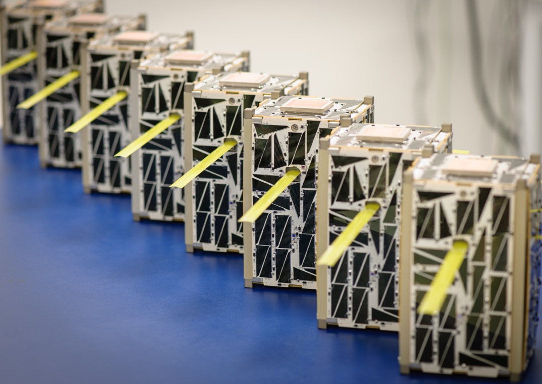 Individual satellites lined up and deployed on a workbench